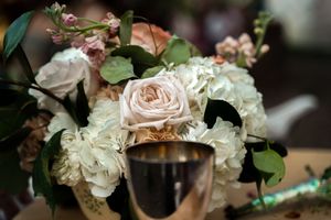 Delicate pink and white roses with greenery arranged for wedding decor.