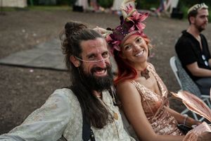 Joyful celebration during an outdoor wedding reception with guests laughing together.