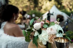 Delicate pink and white roses arranged as wedding decorations with greenery accents.