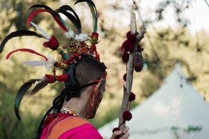 Ornate feathered headpieces and decorative elements at a woodland wedding celebration.