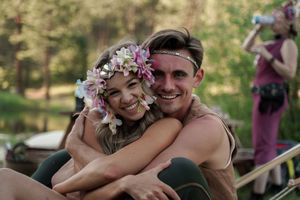 Couple sharing intimate moment outdoors with flower crown decorations.