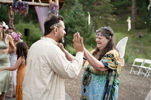 Two people sharing an enthusiastic high-five moment during an outdoor celebration.