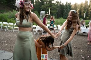 Wedding celebration with guests in earth-toned dresses dancing outdoors.