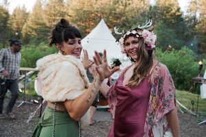 Outdoor celebration in a forest setting with burgundy and green color scheme.