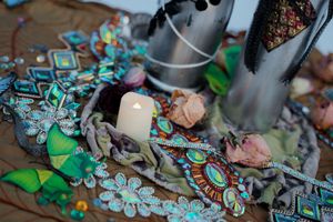Colorful decorative altar display with turquoise ornaments, crystals and a white candle.