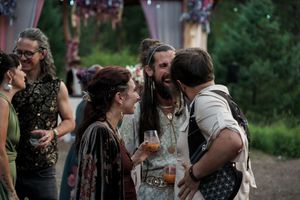 Group of people engaged in animated conversation at an outdoor gathering.