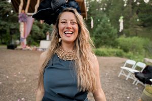 A lively outdoor party scene with guests laughing and celebrating among pine trees.