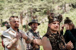 People in costume celebrating at an outdoor medieval-themed event.