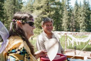 Wedding guests share joyful moments during an outdoor forest celebration.
