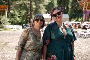 Wedding guests in casual attire celebrate together in an outdoor forest setting.