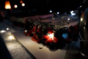 Glowing lantern creating atmospheric lighting on a dark table surface.