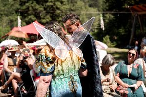 Colorful parasols dot the landscape at a festive outdoor medieval-themed gathering.
