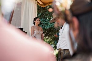 Wedding ceremony guests share emotional moments during an outdoor celebration.
