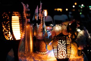 Illuminated decorative lanterns glowing at night with intricate cutout patterns.