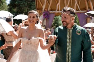 Wedding celebration guests dancing and enjoying festivities under a wooden pavilion.