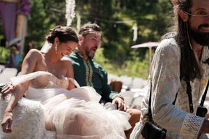Wedding guests seated at an outdoor celebration with rustic medieval-themed decor.