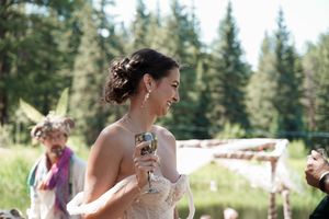 Wedding celebration outdoors with pine trees and natural sunlight in background.