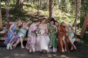 Group poses on rustic wooden swings at outdoor forest celebration.