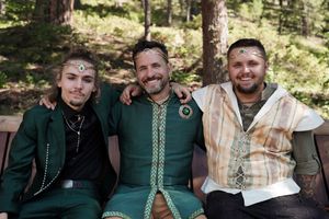 Group photo of people wearing fantasy-themed costumes in a forest setting.