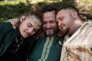Wedding ceremony participants gathered in an intimate woodland setting with floral decorations.