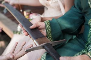 Wedding party involved in a ceremonial tradition outdoors.
