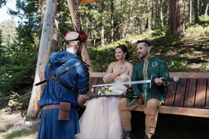 Outdoor wedding ceremony in a forest with wooden benches and natural decor.