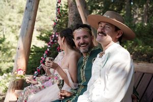 Joyful wedding celebration moments in a sunlit forest clearing with decorative elements.