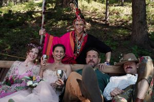 Group celebrating at an outdoor festival with colorful costumes and decorative elements.