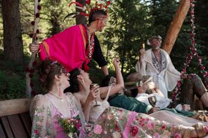 Forest wedding scene with colorful floral decorations and natural wood accents.