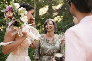 A heartfelt moment captured during an outdoor wedding ceremony in a forest setting.