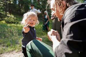Candid moments shared between wedding guests during an outdoor forest celebration.