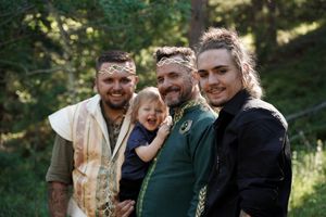 Wedding guests share joyful laughter during an outdoor forest ceremony.