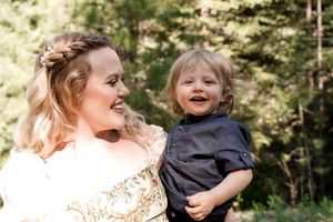 A joyful moment shared between two people at a wedding celebration in a forest setting.