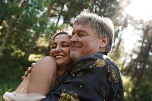 A tender embrace shared between two people during an outdoor wedding celebration.
