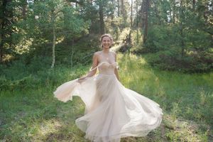 Ethereal wedding dress twirling in a sunlit forest clearing.
