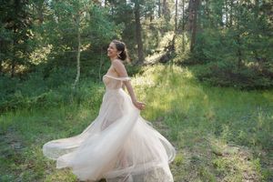Flowing white wedding gown spinning in a magical forest setting.