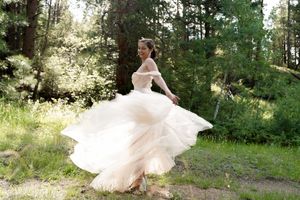 Wedding dress twirling in motion against a forest backdrop.