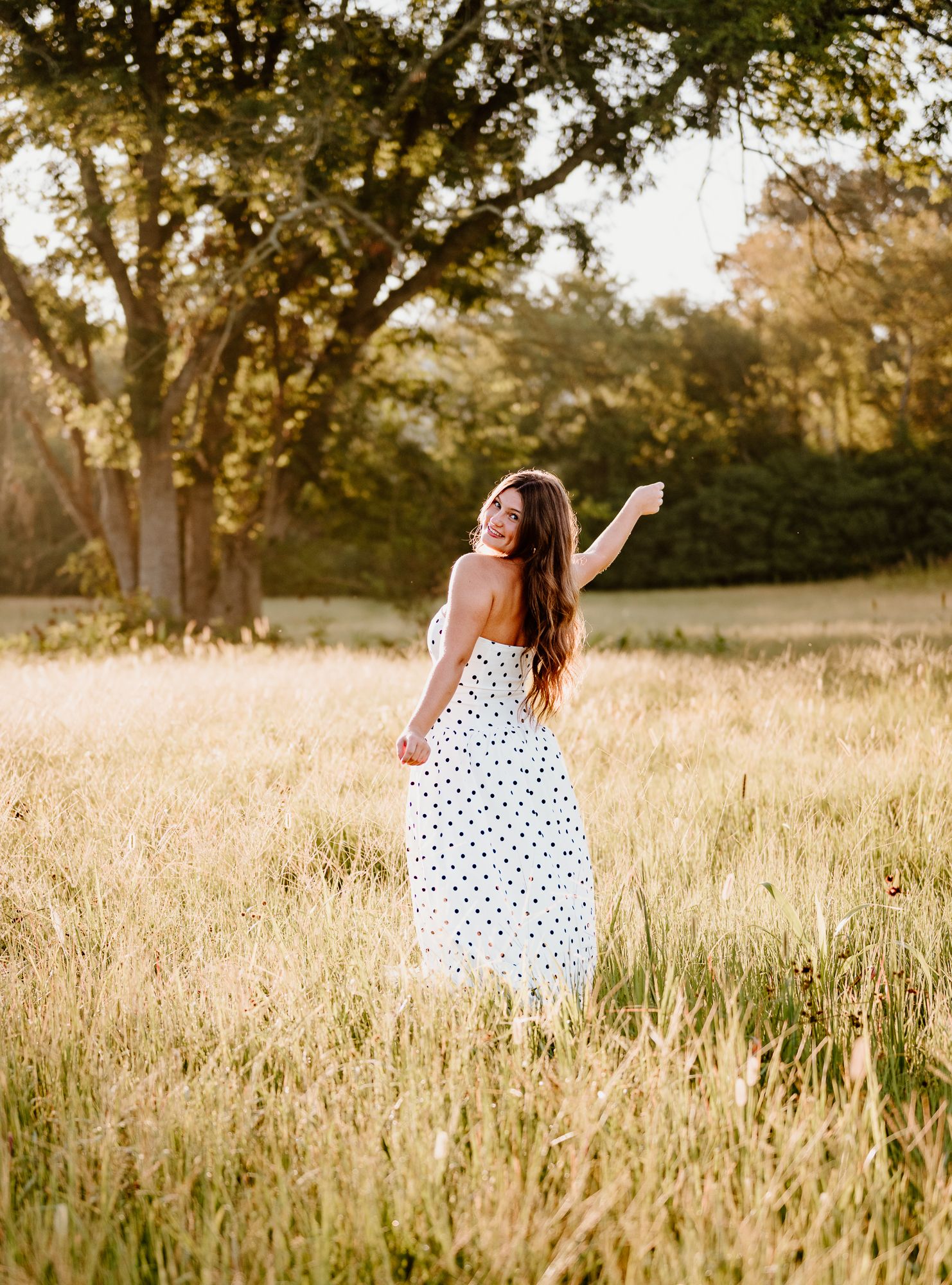 A blue floral dress twirls in a spring meadow filled with daffodils at golden hour while wearing white boots.