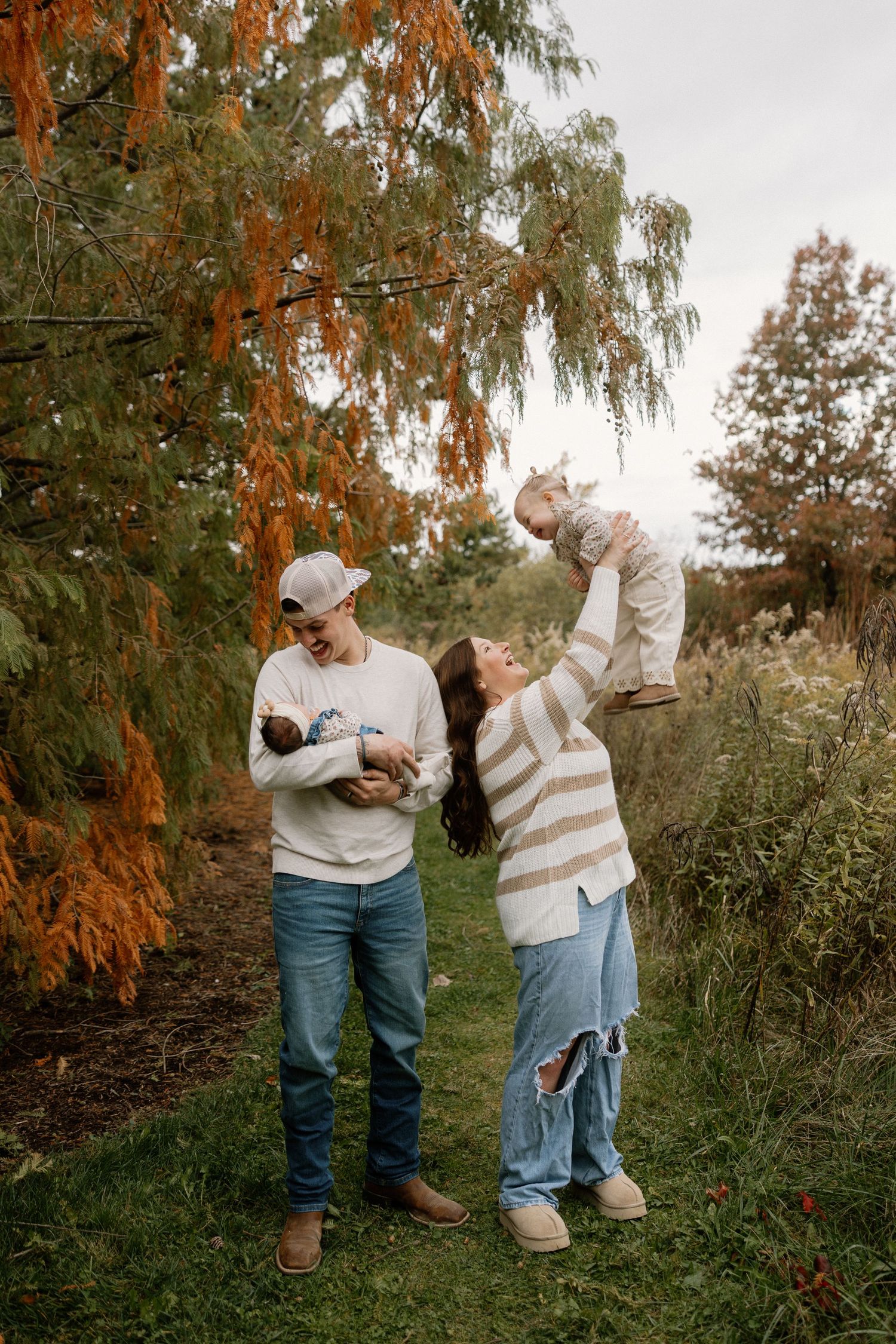 A couple shares an intimate moment on a black couch, with one person wearing ripped jeans and a white shirt.