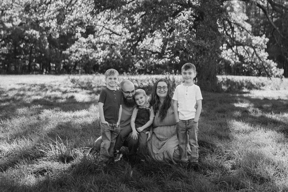 A series of black and white photographs showing a group of people sitting together outdoors on grassy slopes.