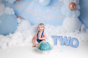 Blue and white balloon arch setup with sparkly decorations for second birthday celebration.