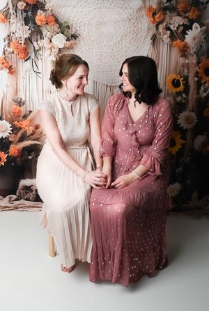 Friends sharing candid moments and laughter during a photo session with floral decorations.