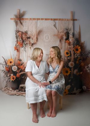 Studio portraits with rustic autumn-themed backdrop featuring sunflowers and wooden elements.