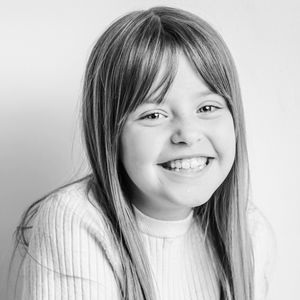 Series of black and white portraits capturing natural smiles in casual sweaters.