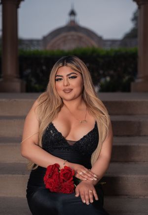Formal portrait with red roses framed by classical architecture.