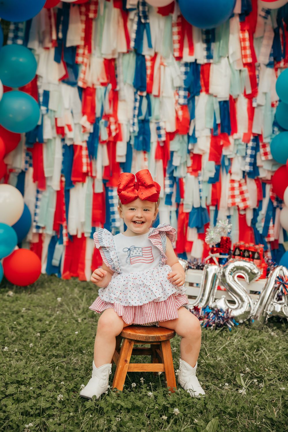 Patriotic themed photo setup with red white and blue streamers and decorative elements.