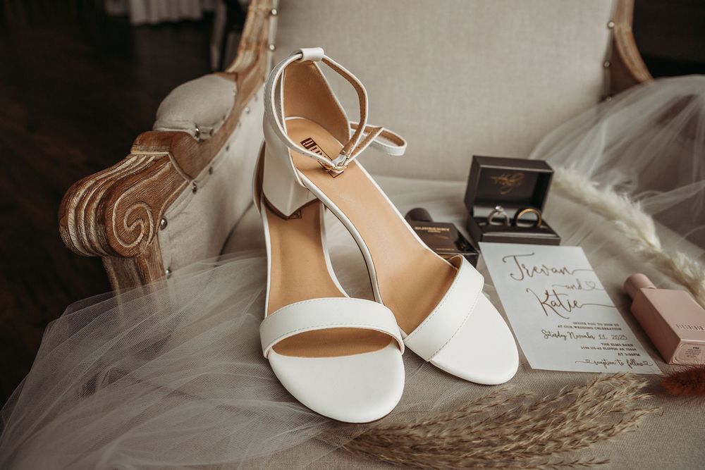 Elegant white bridal shoes arranged with wedding details and soft textiles.