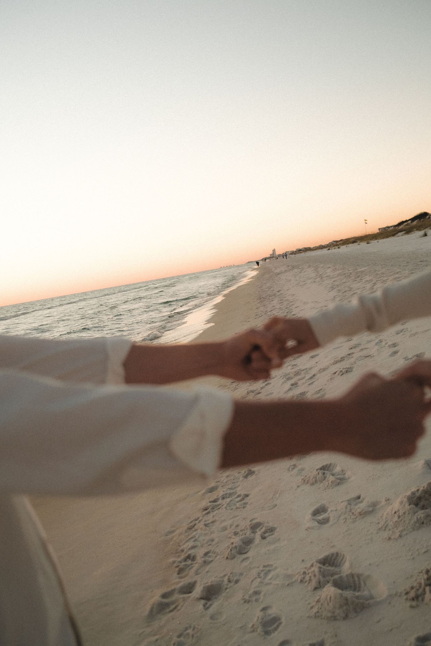 Scenic beach landscape at sunset with gentle waves rolling onto sandy shore.