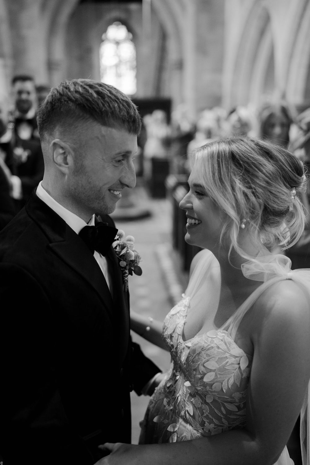 Black and white photo of a bride and groom sharing an intimate moment during their wedding ceremony.