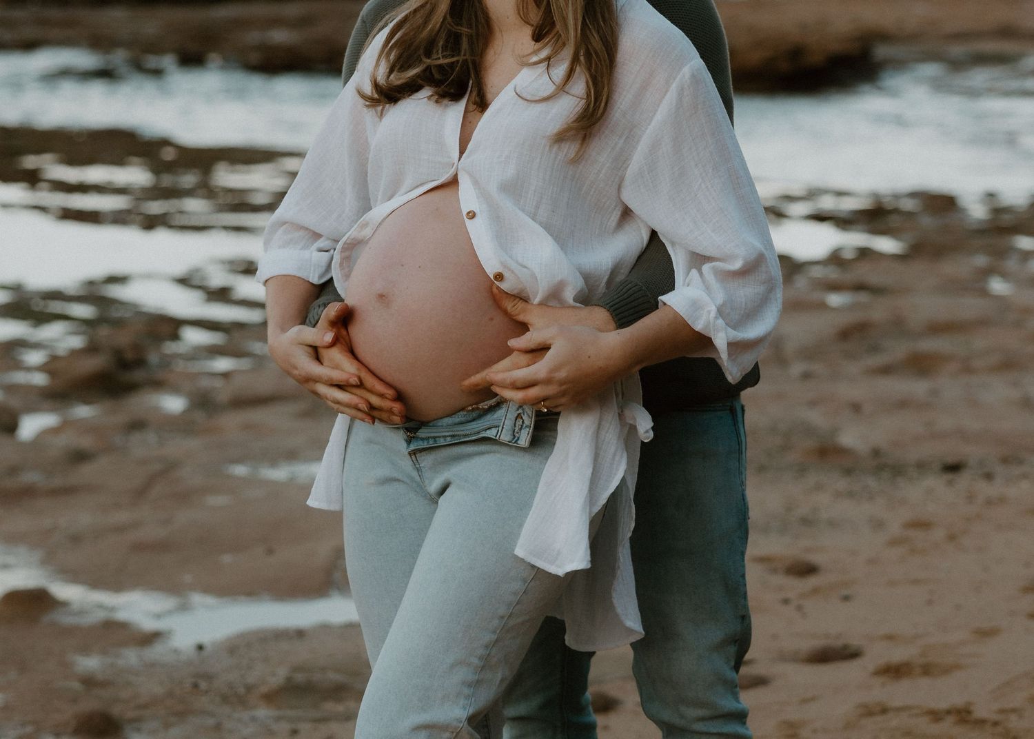 Couple maternity shoot at sunset, showing baby bump, with soft morning light in Bulli, maternity photos in Woonona, Bulli and the Illawarra.